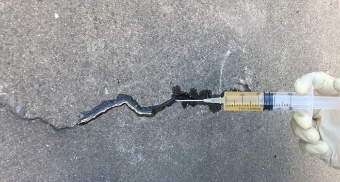 Bridge-deck-repair-team-sealing-surface-cracks-with-epoxy-resin